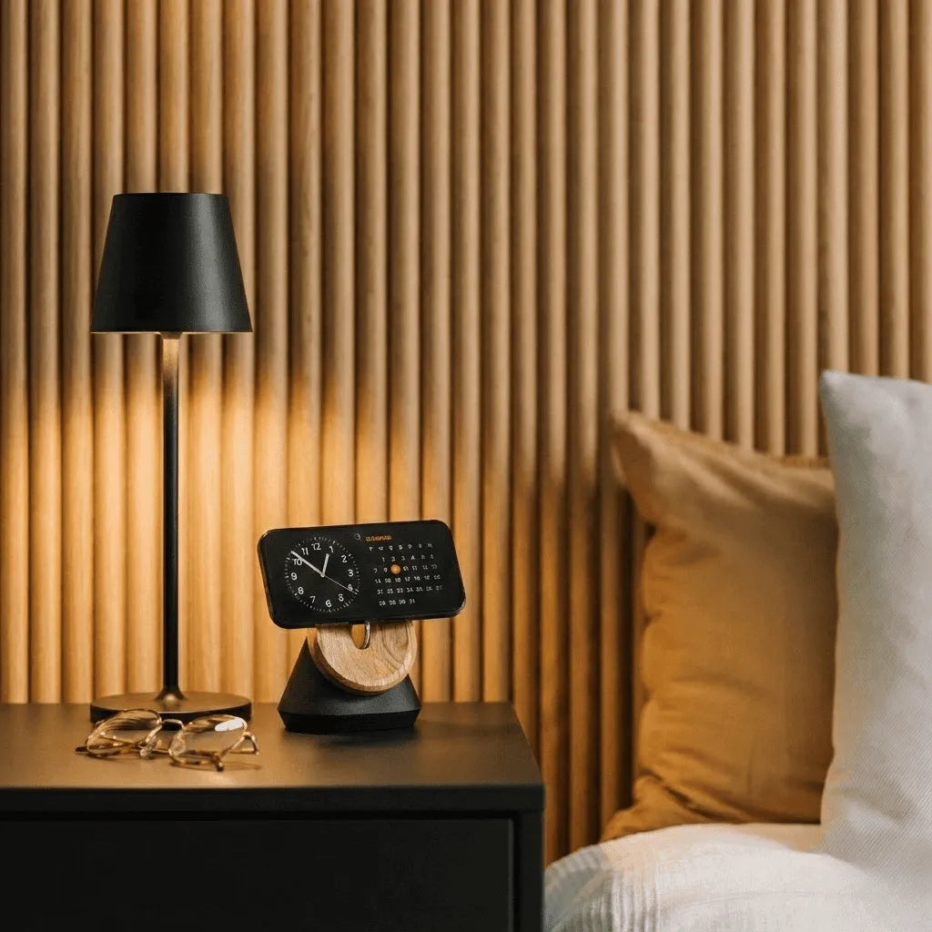 Luminária de cabeceira Éclat Prestige acesa em quarto aconchegante com painel de madeira ao fundo, criando iluminação suave.