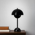 Luminária de mesa Aurora Ébano Preta sobre móvel de madeira, peça de design premium Larvivaz com toque minimalista e acabamento fosco.