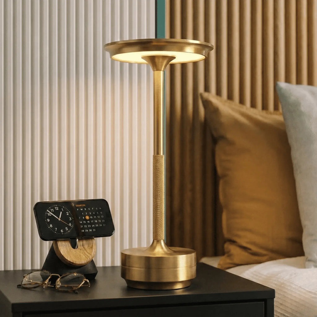 Luminária de mesa usada como luz de cabeceira em quarto moderno, oferecendo iluminação confortável para leitura sem cansar a vista.