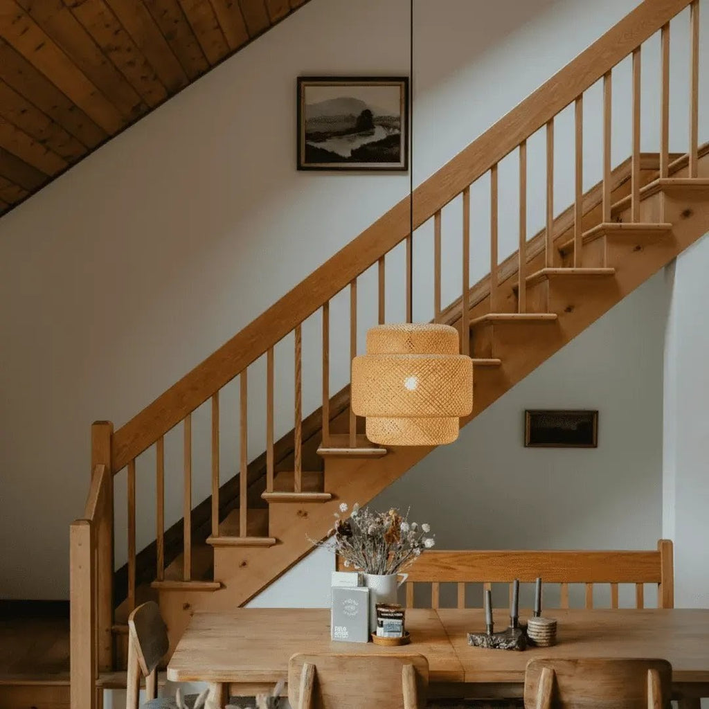 Luminária de teto Larvivaz Imperial Rattan decorando hall e escada, iluminação sofisticada e ambiente contemporâneo elegante.