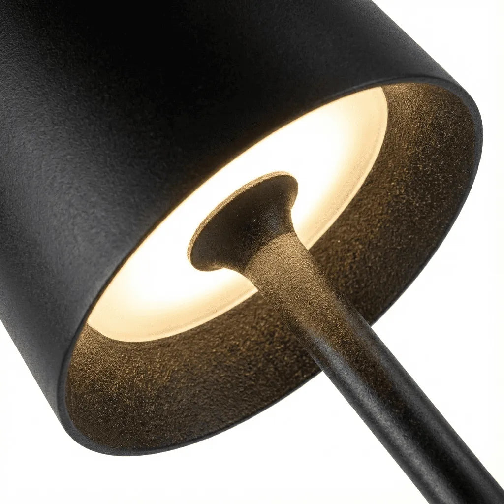 Detalhe da parte superior da luminária de mesa preta, destacando o formato cônico da cúpula e o acabamento fosco sem reflexos.