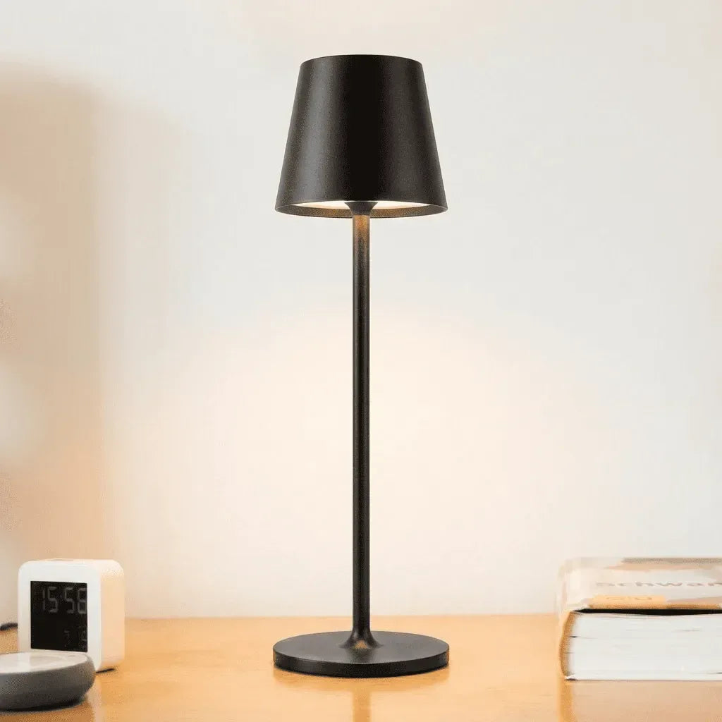 Luminária Éclat Prestige posicionada em mesa de escritório home office de madeira clara, compondo uma decoração clean e funcional.