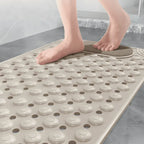 Pés sobre o tapete para banheiro antiderrapante Elysian, demonstrando a segurança e o conforto do uso.